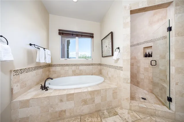 a spacious bathroom with a tub sink and mirror