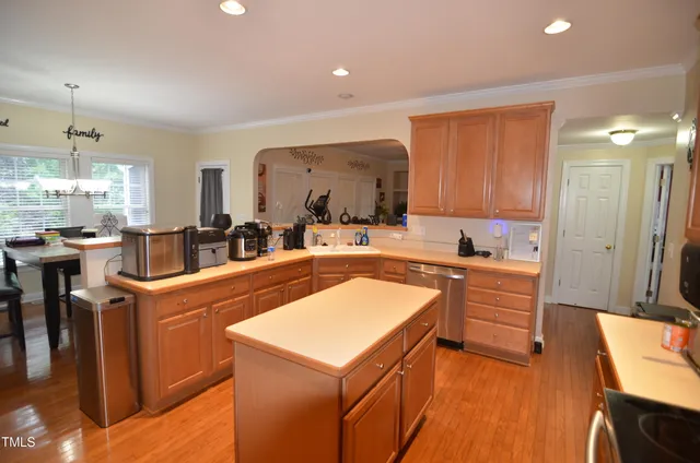 a large kitchen with stainless steel appliances wooden floor and a counter top space