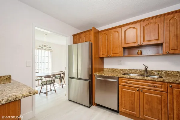 a kitchen with stainless steel appliances granite countertop a refrigerator sink and cabinets