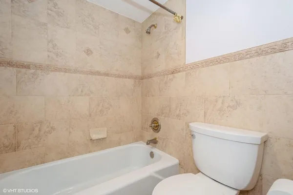 a white toilet sitting next to a bath tub and a shower