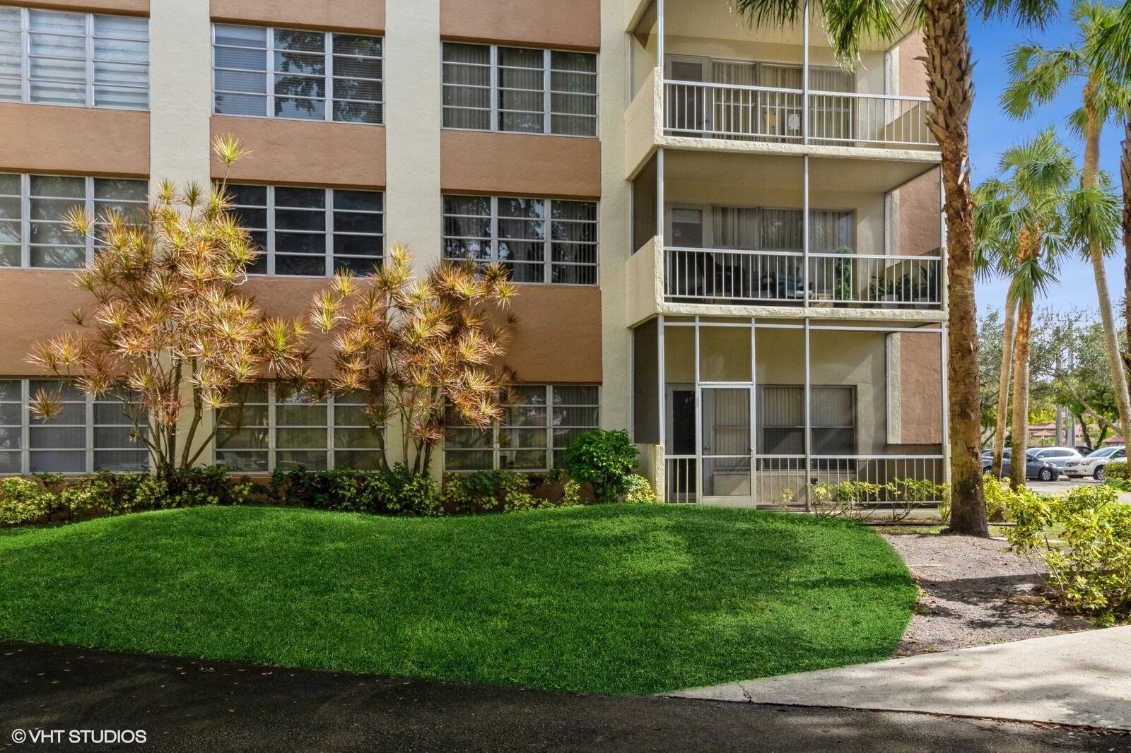 10777 West Sample Road, Unit 101 Coral Springs, FL 33065 - Photo 5 of 36 a view of a building with a yard