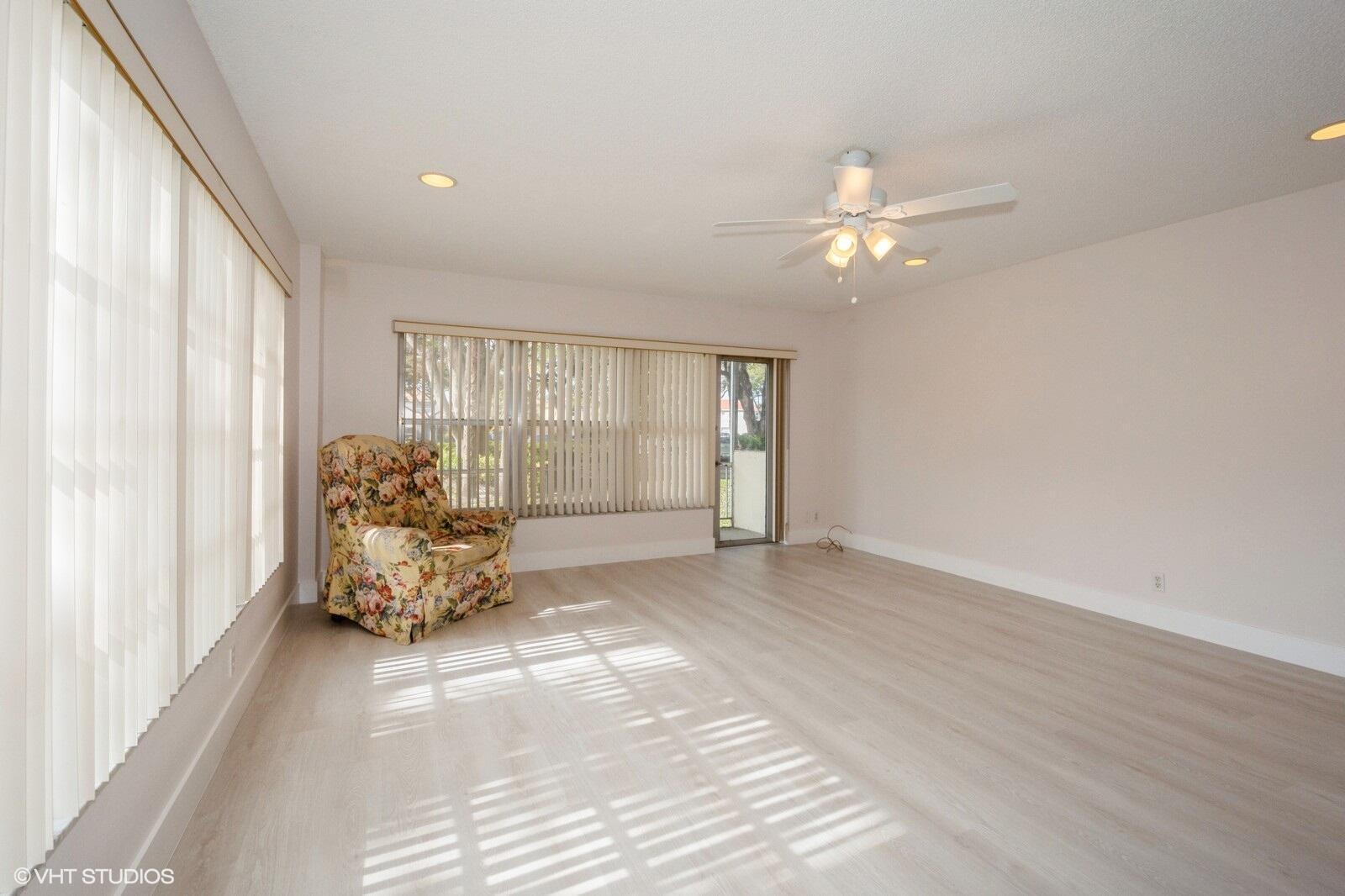 10777 West Sample Road, Unit 101 Coral Springs, FL 33065 - Photo 9 of 36 wooden floor in an empty room with a window