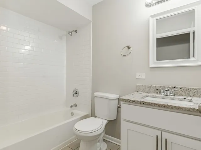 a bathroom with a sink toilet vanity and shower