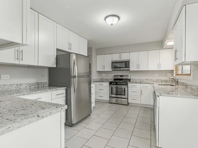 a kitchen with a sink a refrigerator and a stove