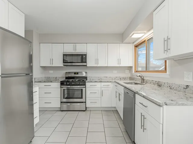 a kitchen with cabinets stainless steel appliances and a sink