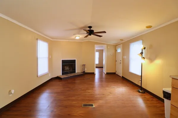 a view of a livingroom with wooden floor and a ceiling fan
