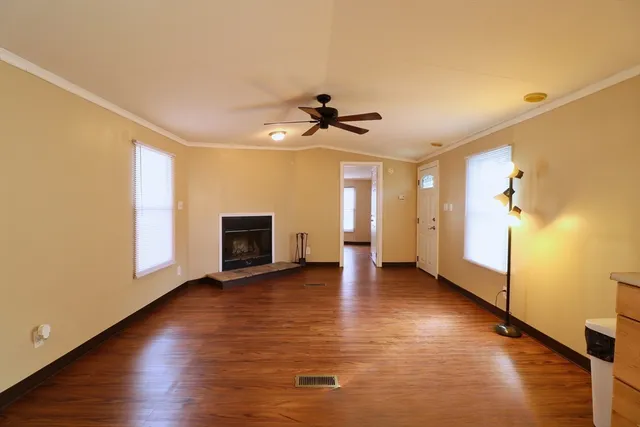 a view of a livingroom with wooden floor and a ceiling fan