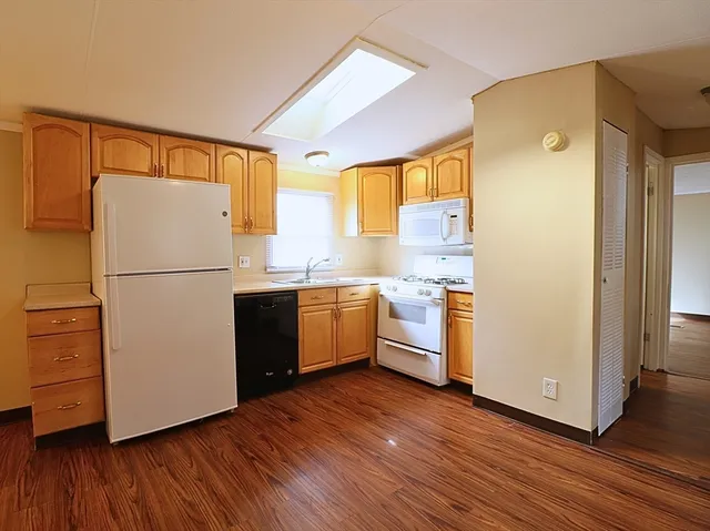 a kitchen with a refrigerator wooden floor and a sink