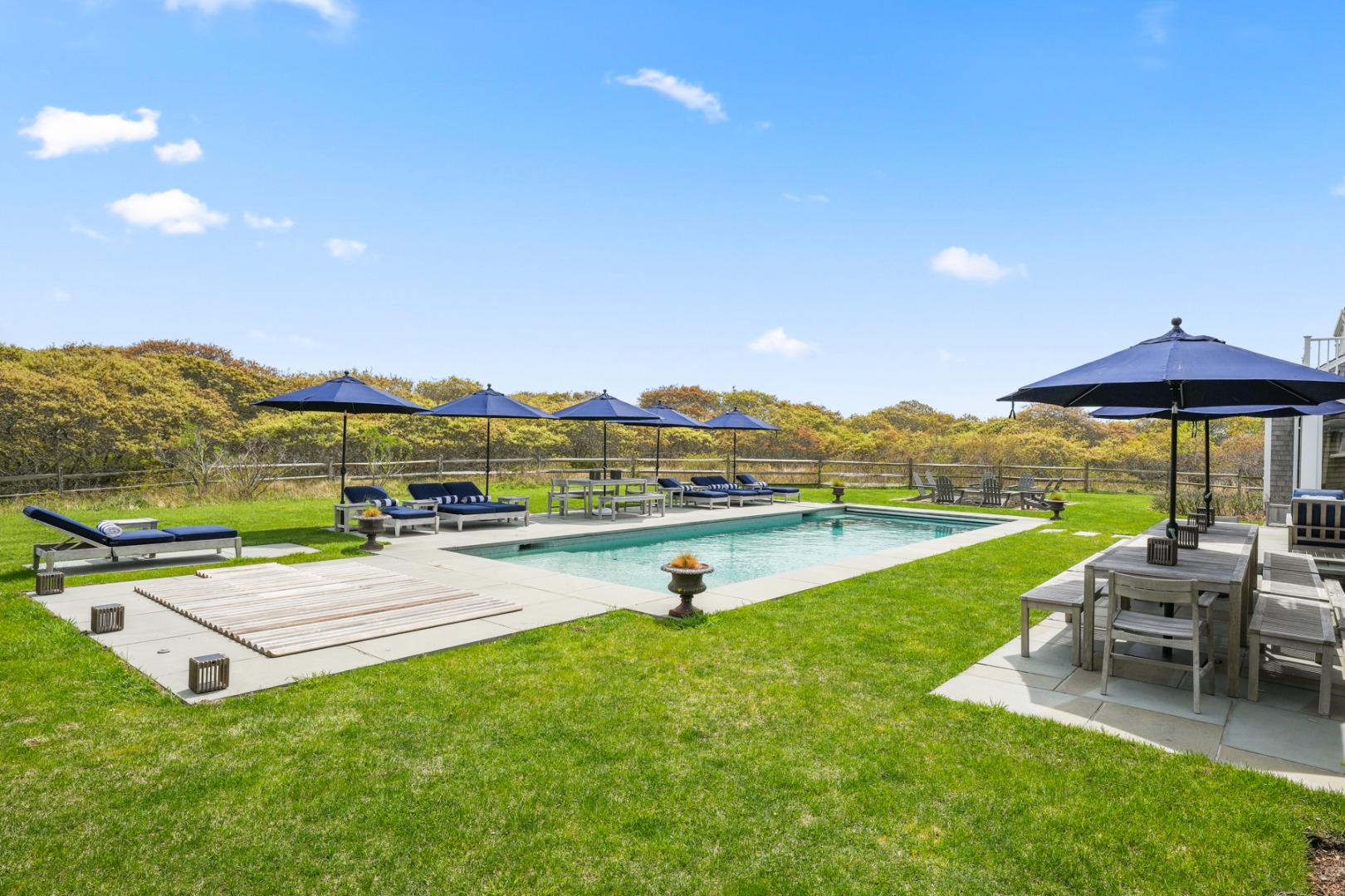21 Quidnet Road Nantucket, MA 02554 - Photo 55 of 62 a view of a lake with a garden and couches under an umbrella