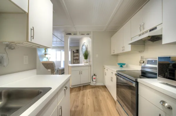 a kitchen with granite countertop white cabinets and stainless steel appliances