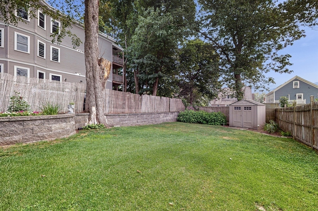 13 Robbins Street, Unit 1 Waltham, MA 02453 - Photo 27 of 29 a view of yard with small cabin and wooden fence