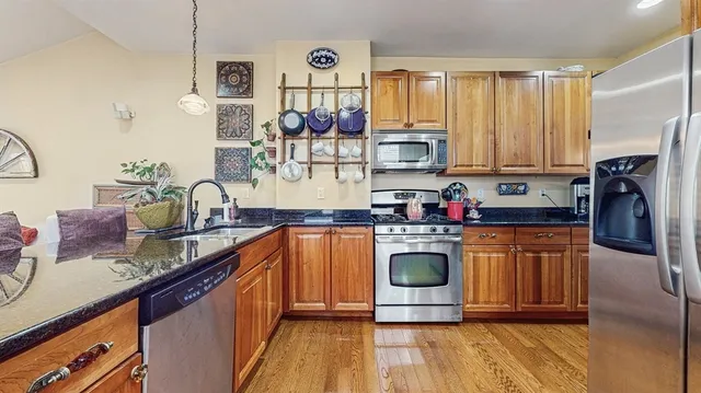 a kitchen with stainless steel appliances granite countertop a stove a sink and a refrigerator