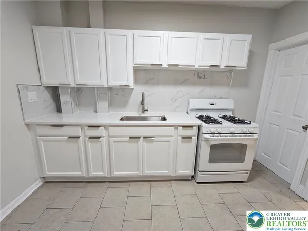 a kitchen with white cabinets and white appliances