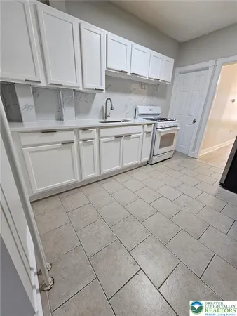 a kitchen with a sink a stove and cabinets