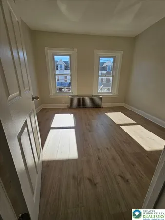 a view of an empty room with wooden floor
