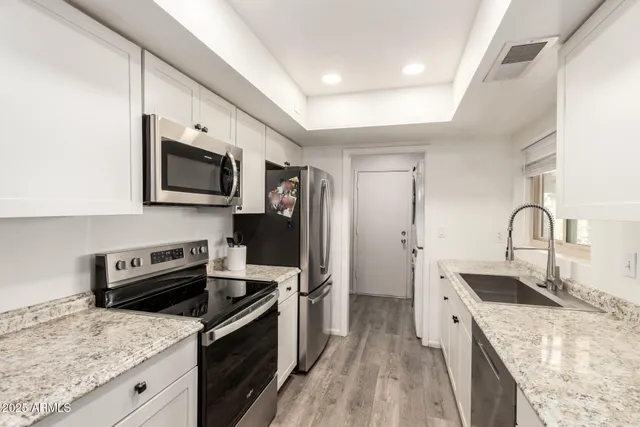 a kitchen with a sink appliances and cabinets