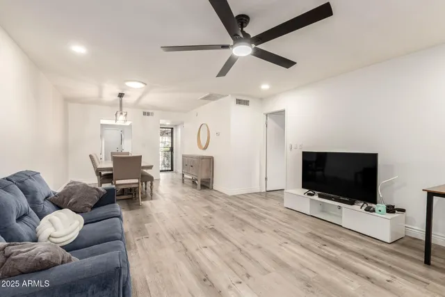 a living room with furniture and a wooden floor