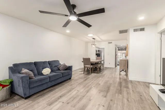 a living room with furniture a clock and wooden floor