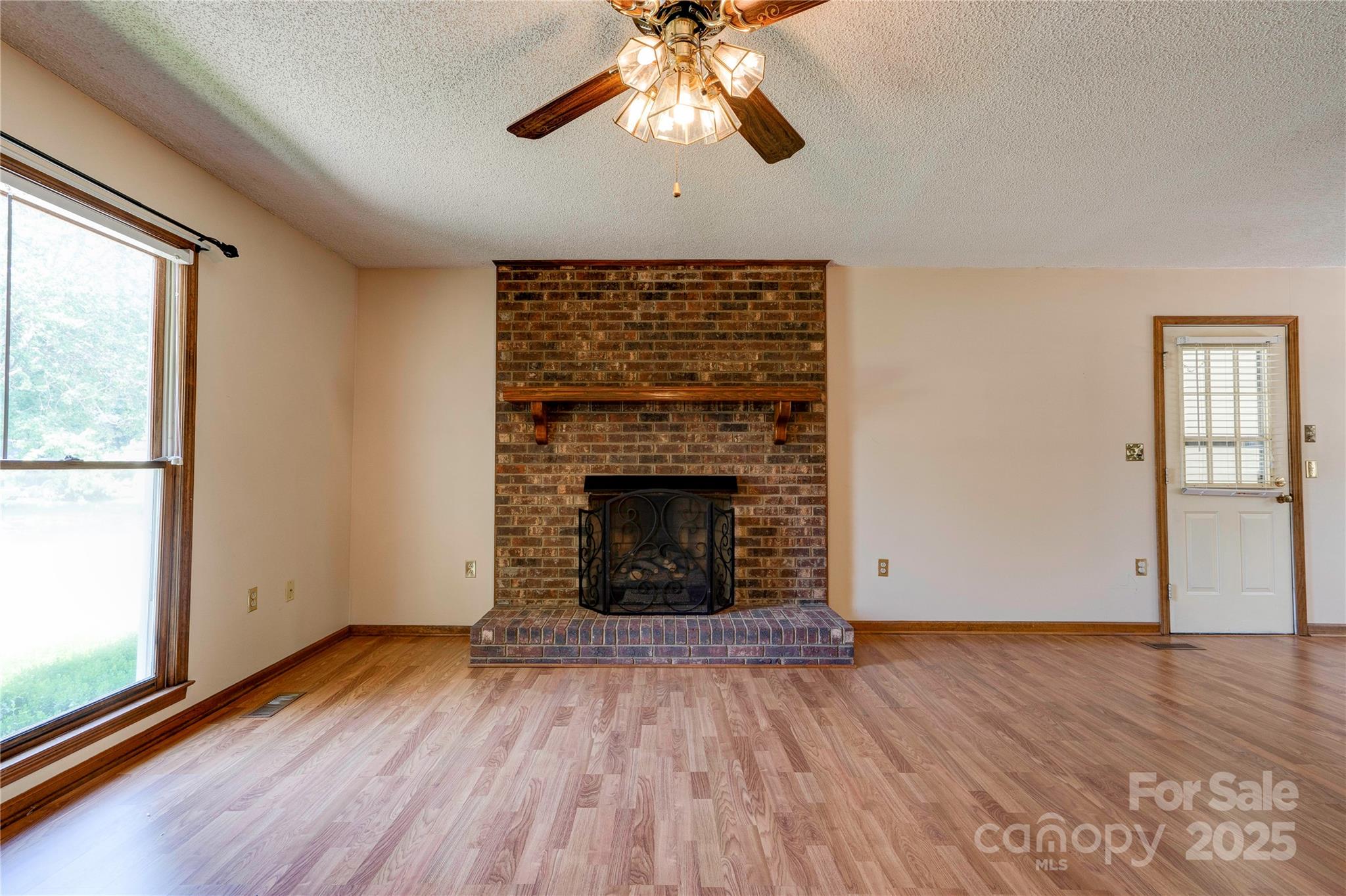 145 Ball Park Road Lawndale, NC 28090 - Photo 11 of 37 an empty room with wooden floor a chandelier fan and windows