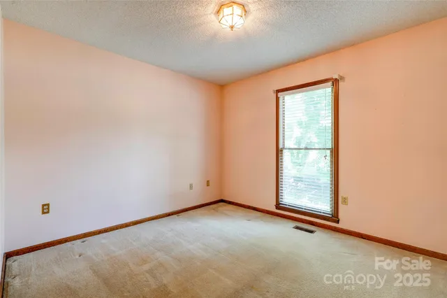 an empty room with a chandelier fan