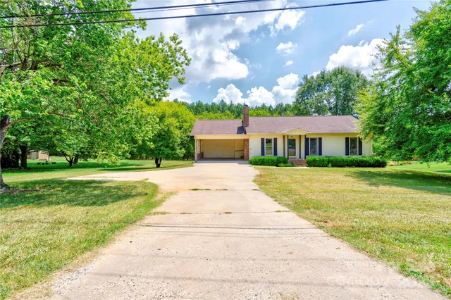 a front view of a house with a yard and trees