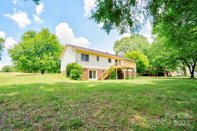 a view of green field with tree in front of it