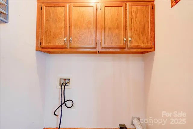 an empty room with wooden floor a chandelier fan and windows