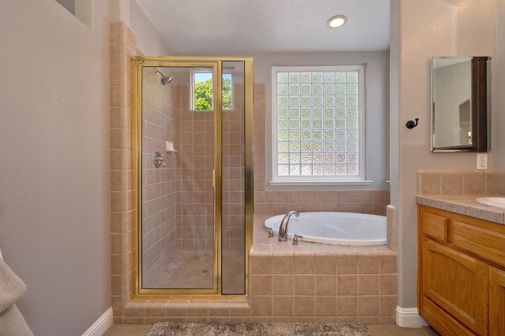 1685 Iroquois Road Rocklin, CA 95765 - Photo 32 of 73 a bathroom with a granite countertop bathtub a shower and a sink