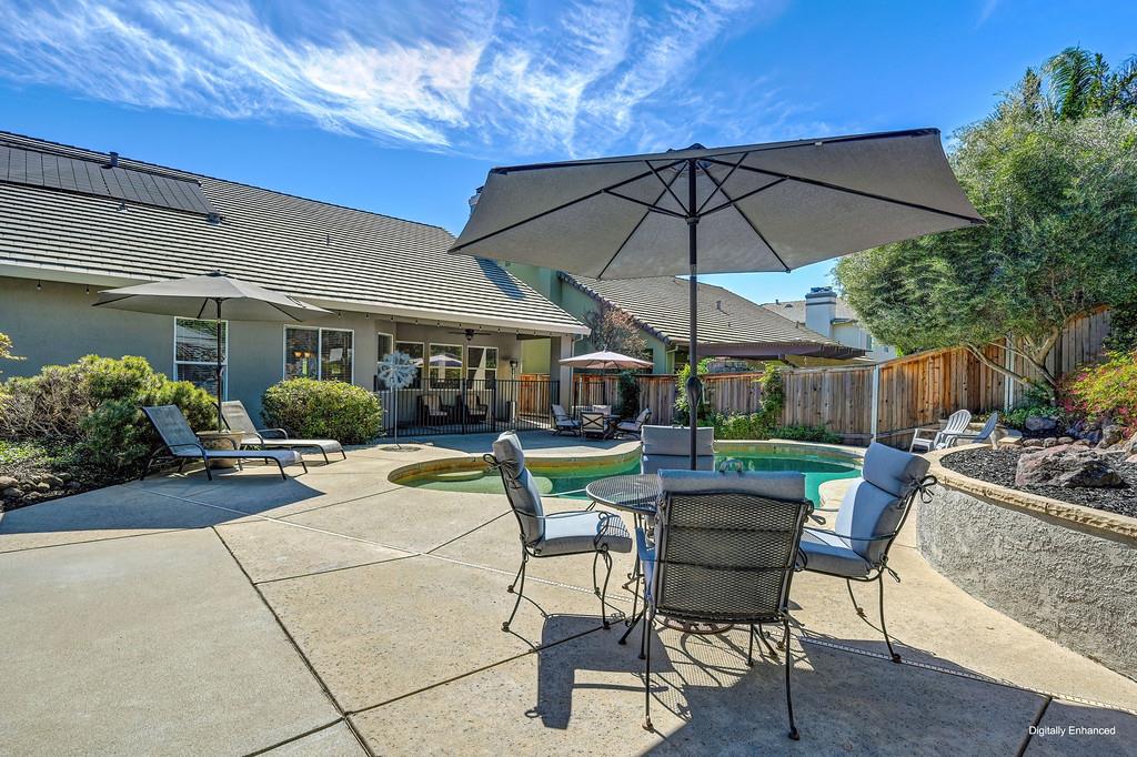 1685 Iroquois Road Rocklin, CA 95765 - Photo 57 of 73 a view of a patio with a dining table and chairs under an umbrella
