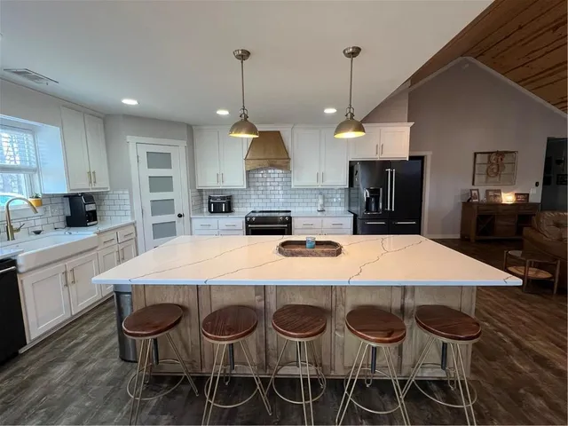a kitchen with a dining table chairs stainless steel appliances and cabinets