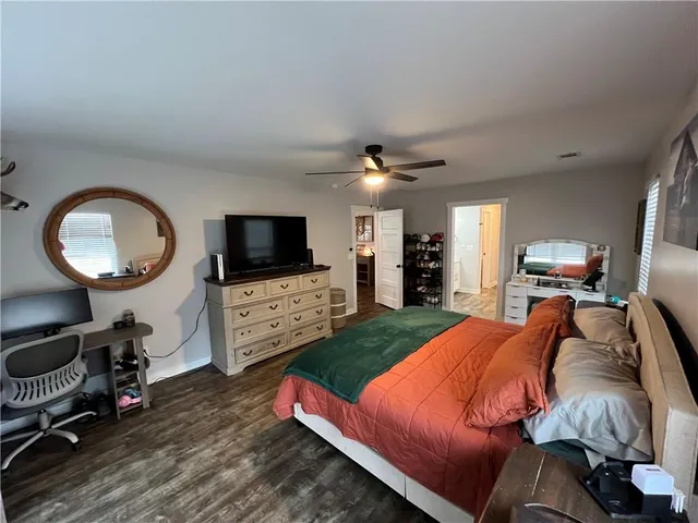 a bedroom with furniture a flat screen tv and a window