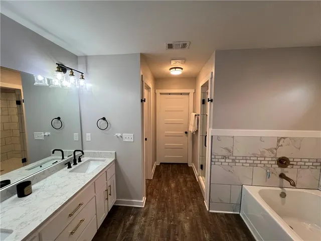 a bathroom with a double vanity sink and mirror with shower