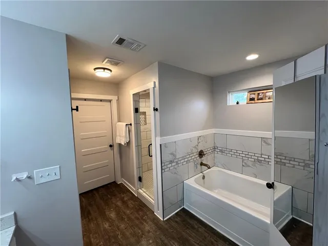 a bathroom with a tub a sink and a shower
