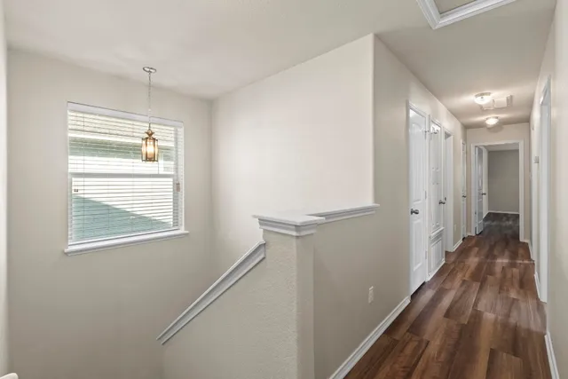 a view of hallway with a large window and wooden floor
