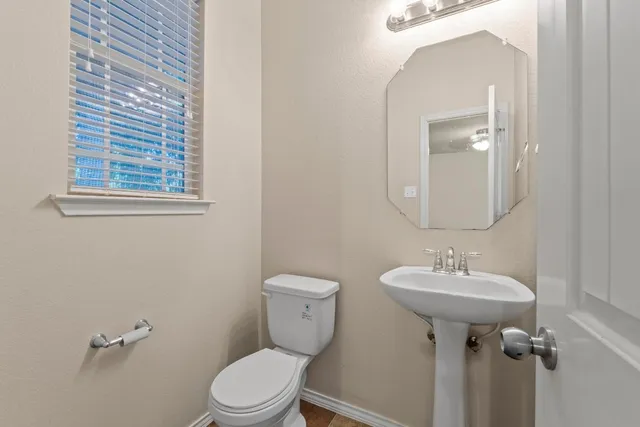 a bathroom with a toilet sink and mirror