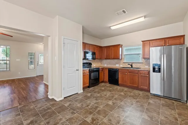 a kitchen with a refrigerator sink and cabinets