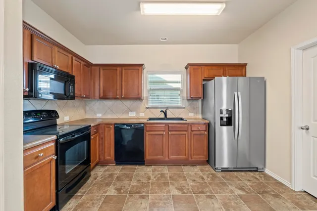 a kitchen with stainless steel appliances granite countertop a refrigerator stove and sink