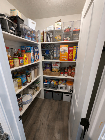 1687 South Windemere Road Santaquin, UT 84655 - Photo 7 of 27 Spacious pantry featuring floor-to-ceiling shelving with multiple storage tiers, built-in cabinetry with closed storage boxes, wood-finish flooring, and ample room for pantry staples and kitchen supplies