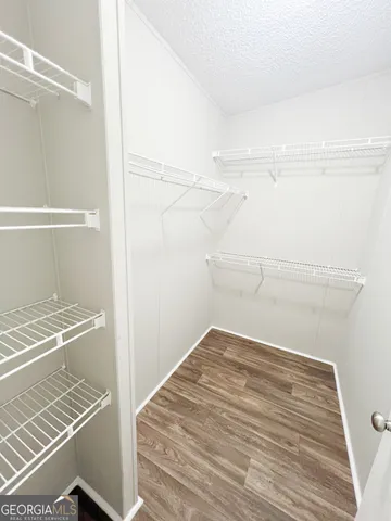 an empty room with wooden floor fireplace and windows