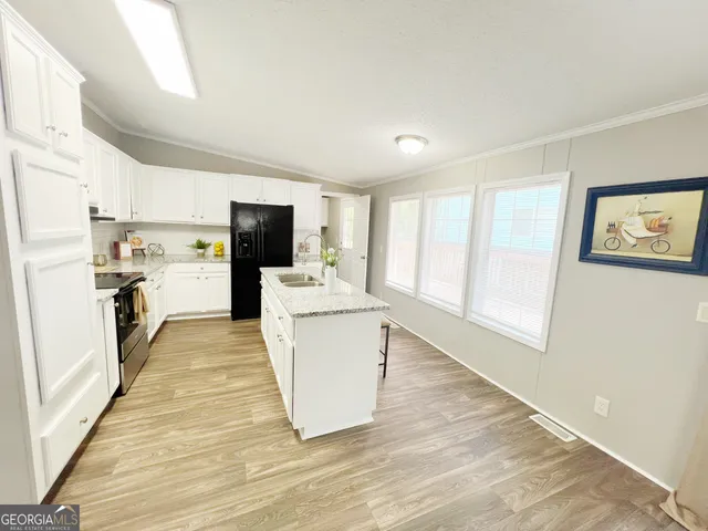 a kitchen with granite countertop a refrigerator and a stove top oven