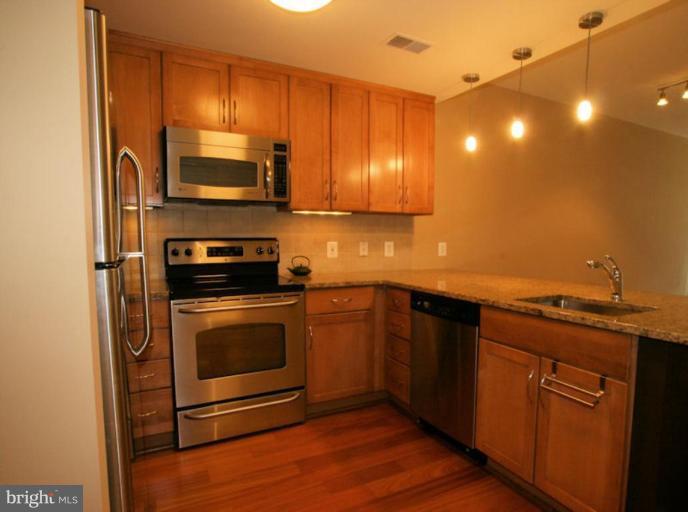 a kitchen with stainless steel appliances a stove a microwave and sink