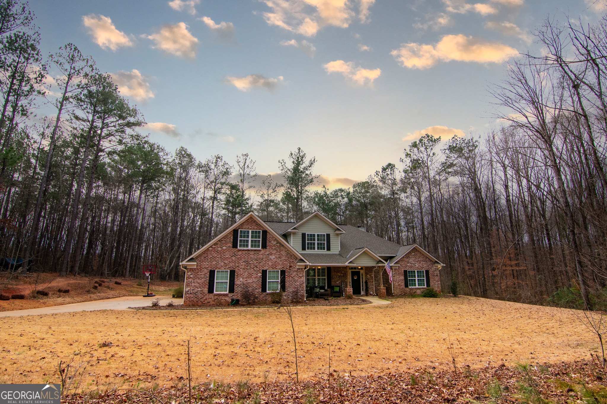 a front view of a house with a yard covered in snow