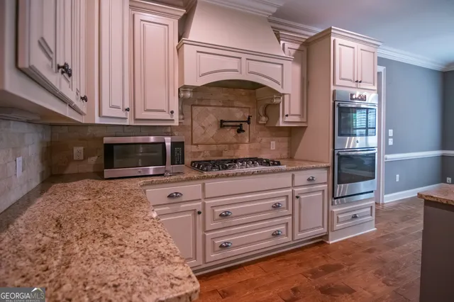 a kitchen with stainless steel appliances granite countertop a stove and a microwave