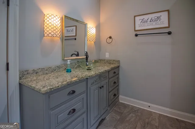 a bathroom with a granite countertop sink and a mirror