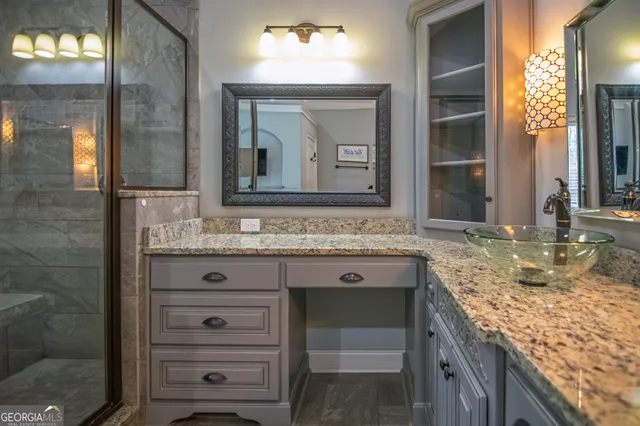 a bathroom with a granite countertop sink and a mirror