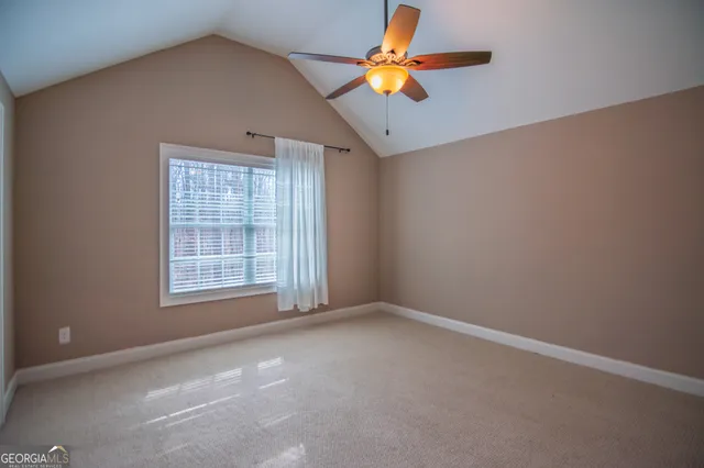 an empty room with a window and a ceiling fan