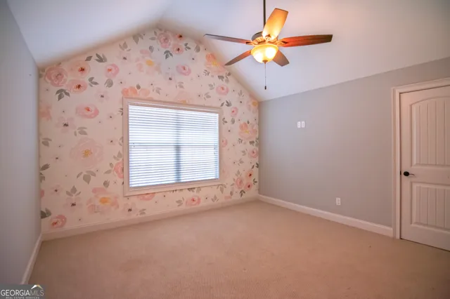 an empty room with a window and a ceiling fan