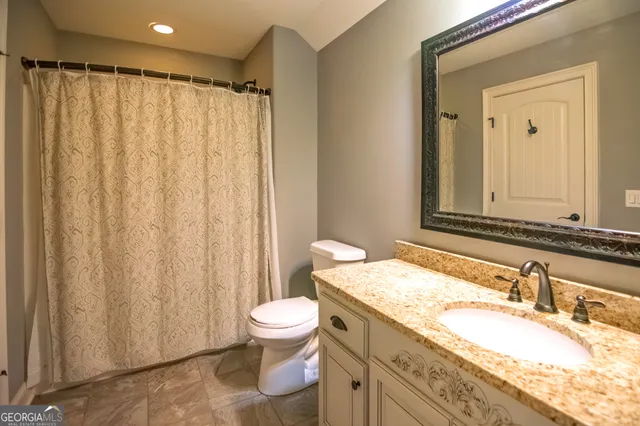 a bathroom with a granite countertop sink toilet and shower