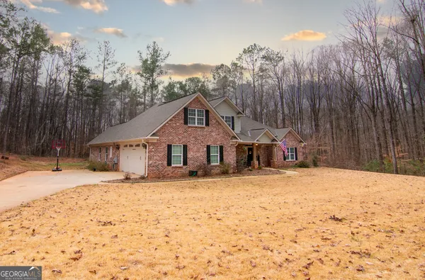 a front view of a house with a yard covered in snow