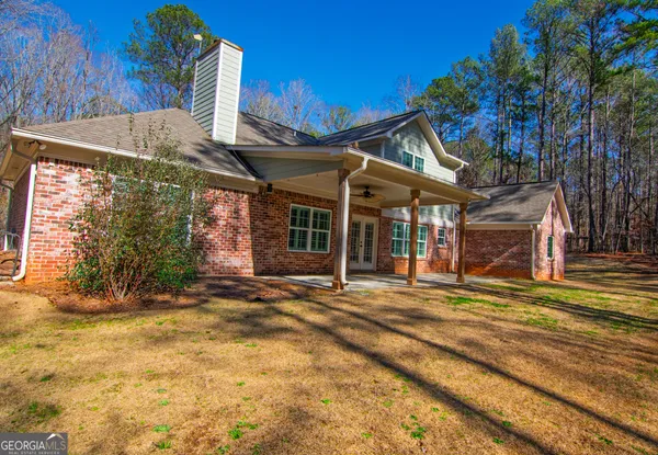 a view of a house with a patio and a yard
